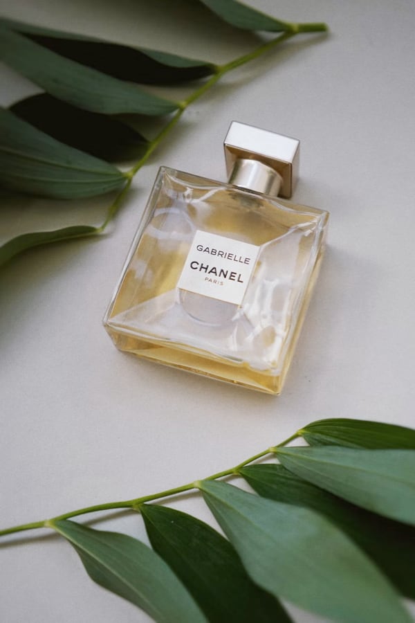 Chanel perfume bottle laying on a white table.