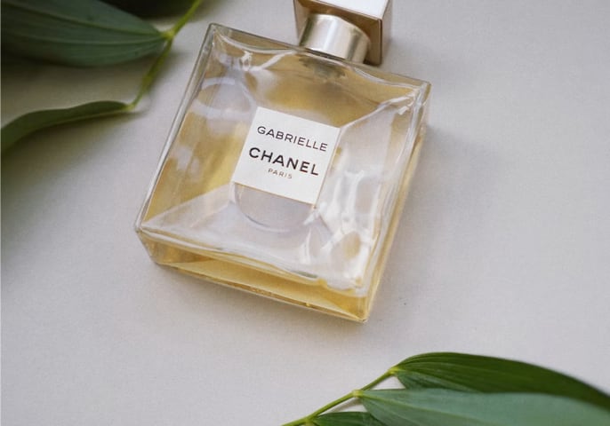 Chanel perfume bottle laying on a white table.